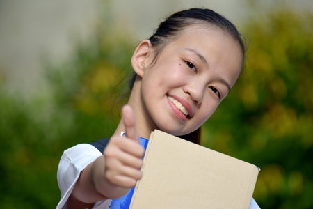 Youthful Asian Female Student With Thumbs Upの写真素材