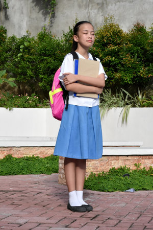 Beautiful Filipina Female Student Daydreaming Standingの写真素材