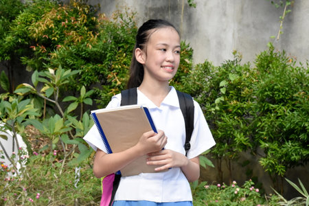Youthful Filipina School Girl Waiting With School Booksの写真素材