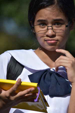 Confused Beautiful Asian Female Student Wearing Glasses With Textbooksの写真素材