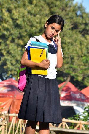 Female Student Decision Making Wearing School Uniform With School Booksの写真素材