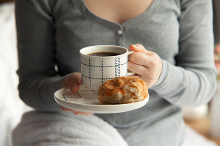 Healthy breakfast in bed served on tray with coffee, cornflakes, croissant and milkの写真素材