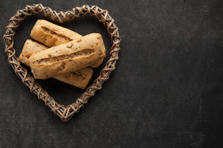 Concept of gluten free buns for allergic people with disease. Variation of bread with wooden heart...
