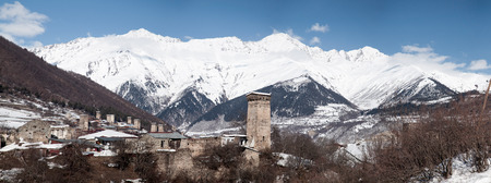Panorama of an old town with snowy mountain on background.