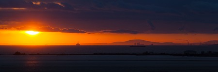 Panorama at the sunset on the beach, blue sky with orange sun.の写真素材