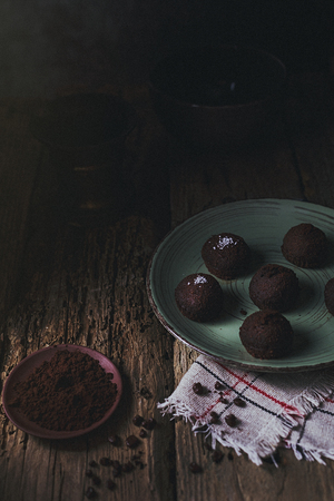 Chocolate truffle candy on a plate set with coffee. Delicious dessert for chocolate lovers. Homemade truffles.の写真素材