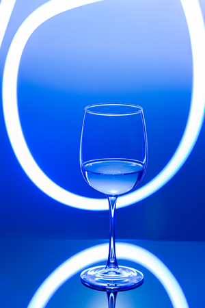 Drink at bar in a night time, wine glass with white wine and freeze light on a background. New year party drink.の写真素材