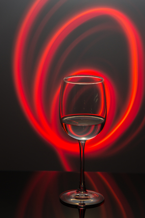 Drink at bar in a night time, wine glass with white wine and freeze light on a background. New year party drink.の写真素材