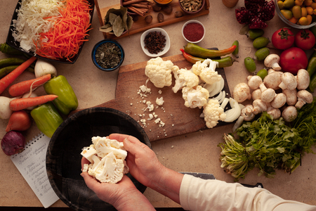 Preparing cauliflower for cooking, cutting vegetables on a cutting board. Healthy food for people on a diet.の写真素材
