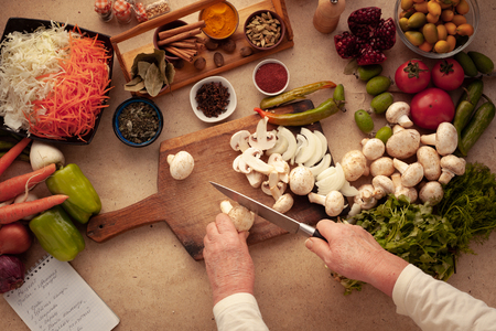 Preparing mushrooms for cooking, cutting vegetables on a cutting board. Healthy food for people on a diet.の写真素材
