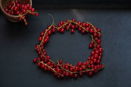Red currant on a dark background with free space for text, ripe vitamins for strong health.