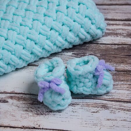 Handcrafted knitted newborn blue baby boots with plaid.の写真素材