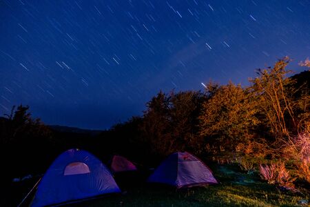 Night camping into the mountain, long exposure stars on the sky photo. Wildlife holidays theme.の写真素材