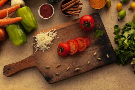 Sliced tomato on cutting board with knife. Cooking vegetarian food, vegetables ingredient for healthy eating.の写真素材