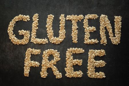 Gluten free word written with cereals on dark background. Concept of healthy lifestyle, gluten free diet.の写真素材