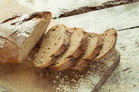 Sliced homemade gluten free bread on cutting board. Healthy lifestyle with organic diet product.