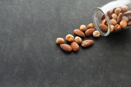 Assortment of nuts in a jar on dark background with free space for text. Healthy snack for beer.の写真素材