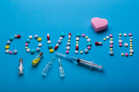 Word Covid-19 wrote with pills on blueの写真素材