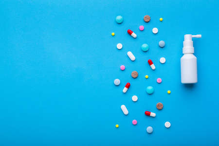 A lot of multi-colored pills on blue background with free space for text, as a concept of medical treatment with a prescription. Painkillers and antibiotics variation, allergy on medicine.の写真素材