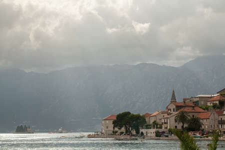 The old town of Montenegro with coastline, dark clouds upon the popular tourist travel destination in Europe. Journey on summertime vacation.の写真素材