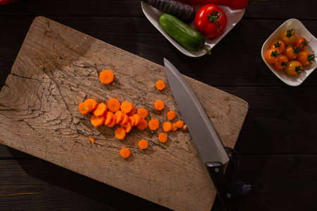 Sliced carrot on cutting board, source of vitamins and ingredients for a healthy snack. The cooking process for the online culinary courses.の写真素材