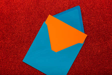 Envelope with blank space for text or greeting on red background, as symbol of getting mail, advertisement element. Corresponds in office, greeting card mockup. New year card.の写真素材