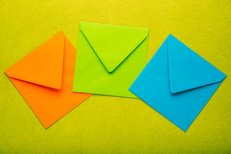 Variation of colorful envelopes on yellow background, a symbol of greeting cards on holidays or...