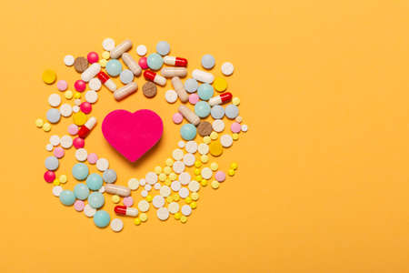 Heart shape figure with a lot of colorful pills as a symbol of special treatment for a healthy heartの写真素材
