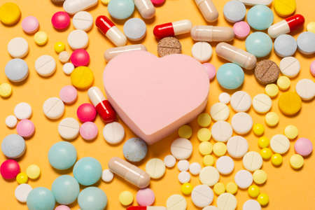 Heart shape figure with a lot of colorful pills as a symbol of special treatment for a healthy heart