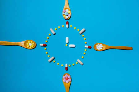 Clock made from colorful pills as a concept of taking medicine in time, by prescription. Addiction...