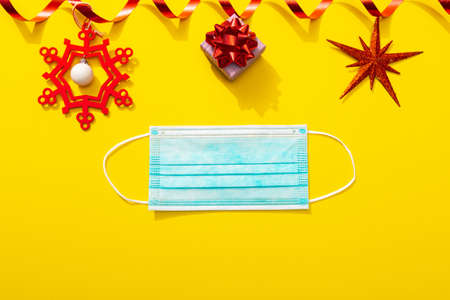Protective face mask with Christmas decoration as a symbol of celebrating with Covid-19 infection....
