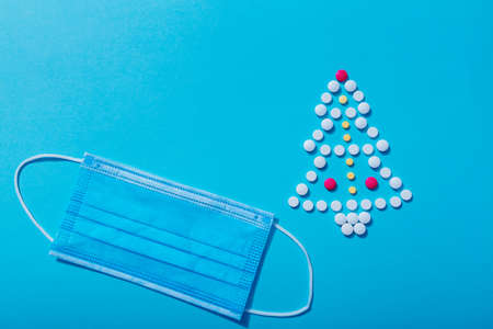 New year's tree made from pills and a protective face mask, the concept of a new year with Covid-19 and medical treatment. Christmas with medicine, how to celebrate when you are sick.の写真素材