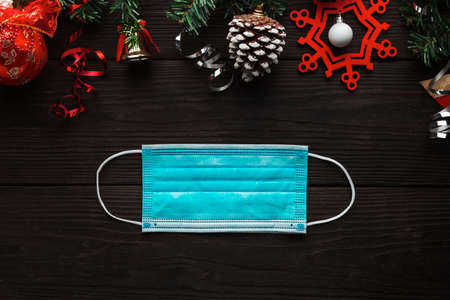 Protective face mask with Christmas decoration as a symbol of celebrating with Covid-19 infection.の写真素材