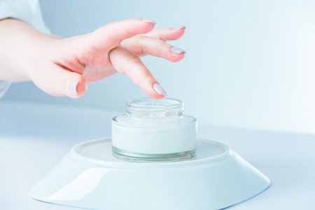 : Close-up woman takes cream, moisturizing lotion from jar. Advertising of antiwrinkle antiaging whitening rejuvenation uv protection women in menopause treatment.の写真素材