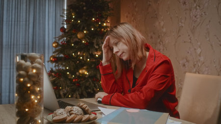 Sad worried woman with cash money and Christmas tree on background, mortgage payment problem.