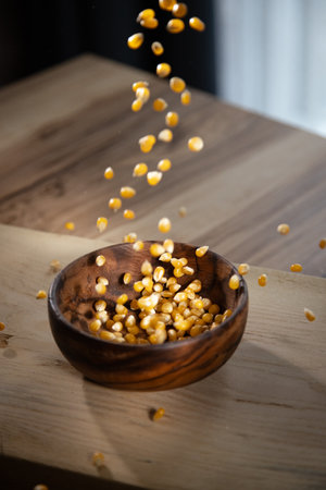 Falling corn seeds into a bowl, preparation of popcorn at home. Making flour from organic ingredientsの写真素材