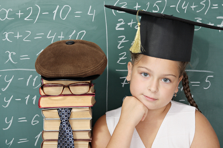 Unusual school concept, schoolgirl with textbooks as a teacherの写真素材