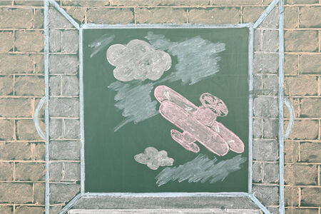 Chalk drawing of airplane in open windowの写真素材