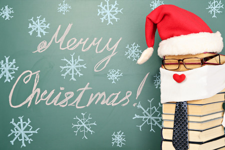 Unusual Santa Claus from books before blackboard with title MERRY CHRISTMAS!の写真素材