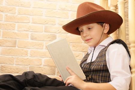 Boy as a cowboy reading bookの写真素材