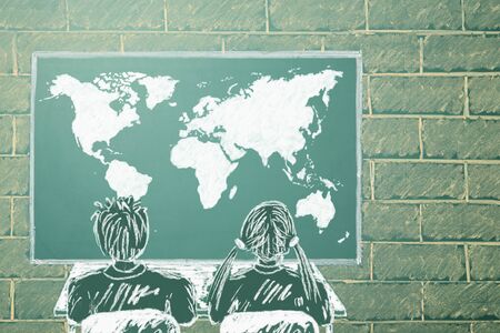 Girl and boy in front of World map on a displayの写真素材