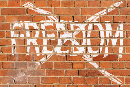 Brick wall with the crossed out word FREEDOMの写真素材