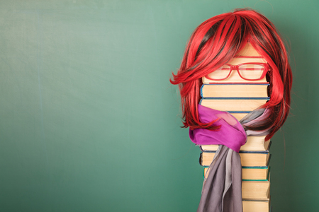 Unusual Beautiful Teacher Girl with Luxurious Red Hair. Copy space on blackboardの写真素材