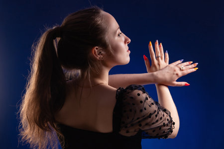 Portrait of a beautiful young girl with multicolored nailsの写真素材