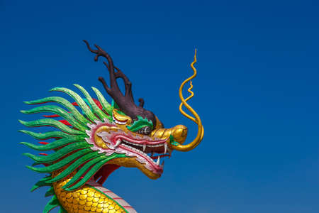 Golden dragon statue on bule sky in the winterの写真素材