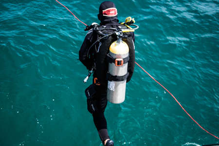 A man wearing a scuba suit jumping to the sea at Chonburi, Thailand.の写真素材