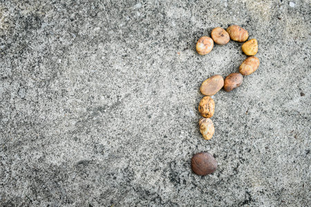 Arrange rocks question mark sign on cement floor.の写真素材