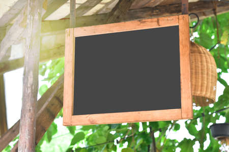 Wooden chalkboard hanging on cottage ceiling with morning light fairの写真素材