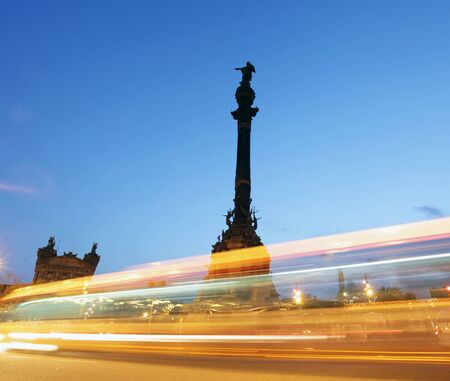 rush of night time traffic around colon monument, barcelonaの写真素材