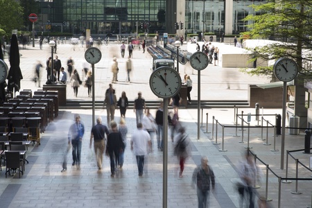 early morning workers rush past the clocks in london's docklands financial districtのeditorial素材